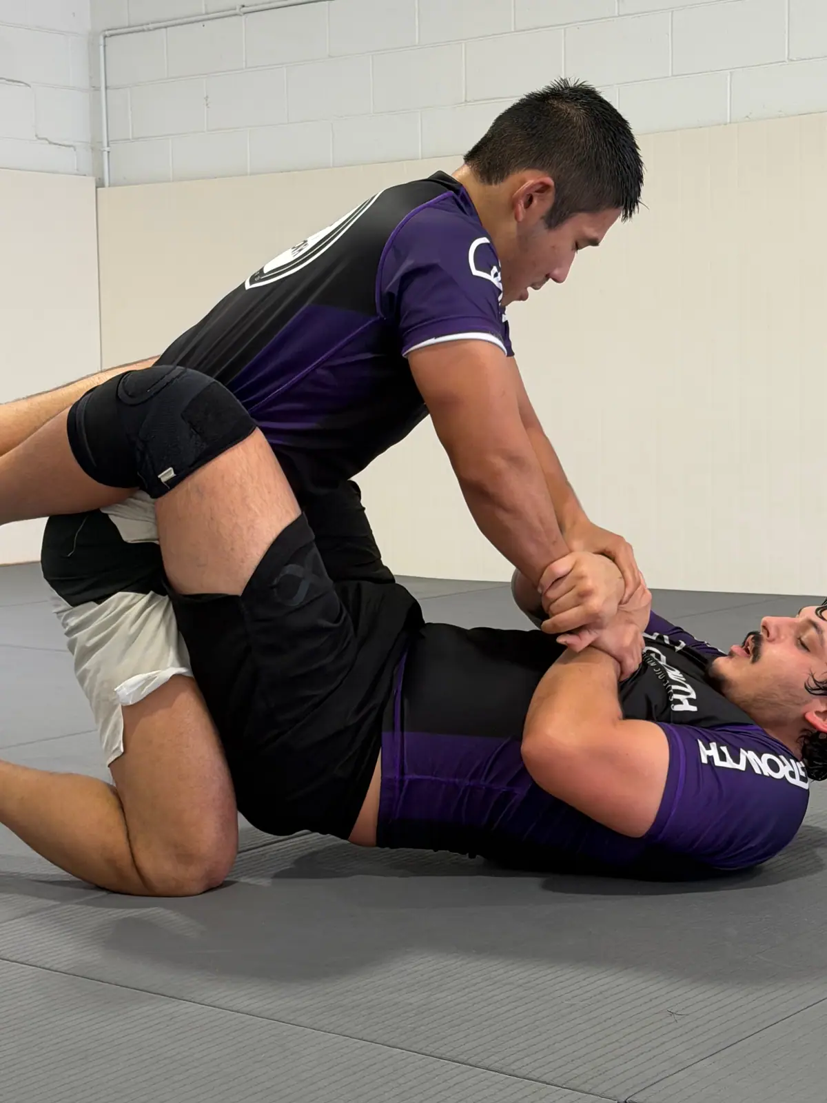 A No-Gi student holding mount
