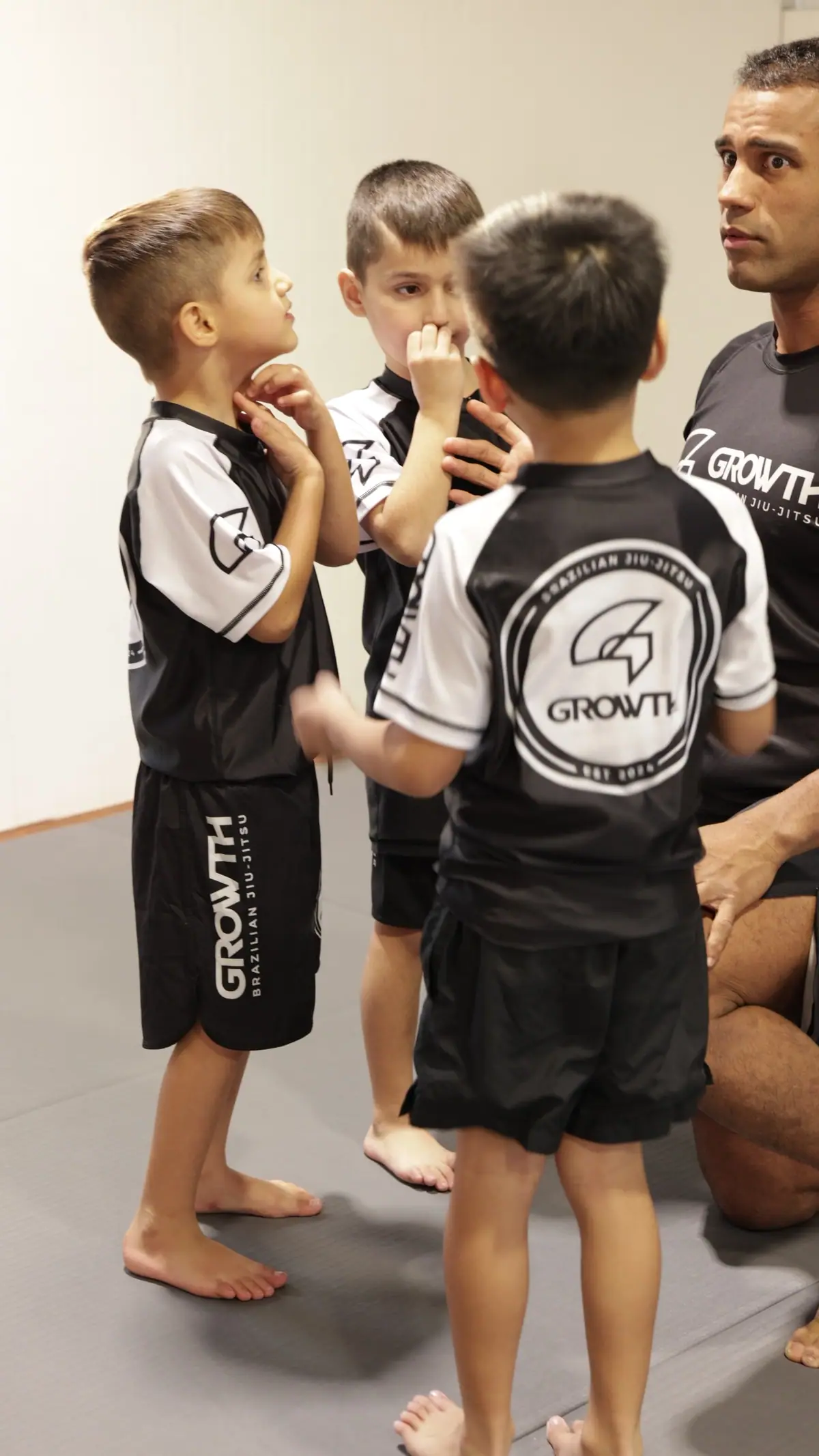 Ícaro coaching a group of kids in a No-Gi class