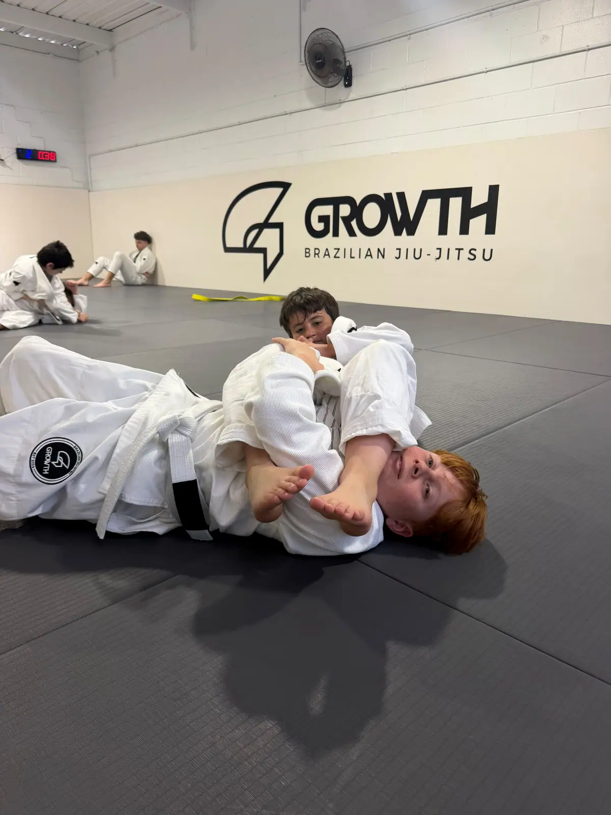 Kids drilling in the gi in front of the Growth wall