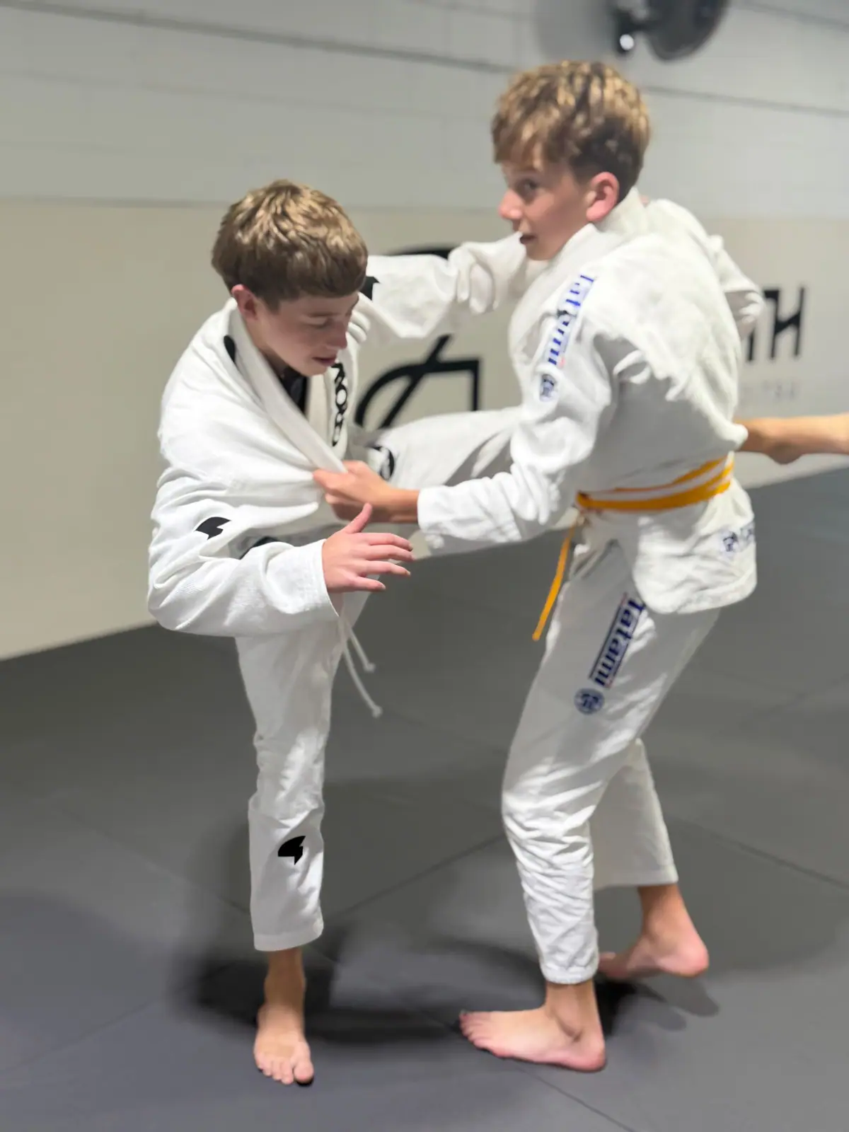 Two yellow belt kids gripping in the gi