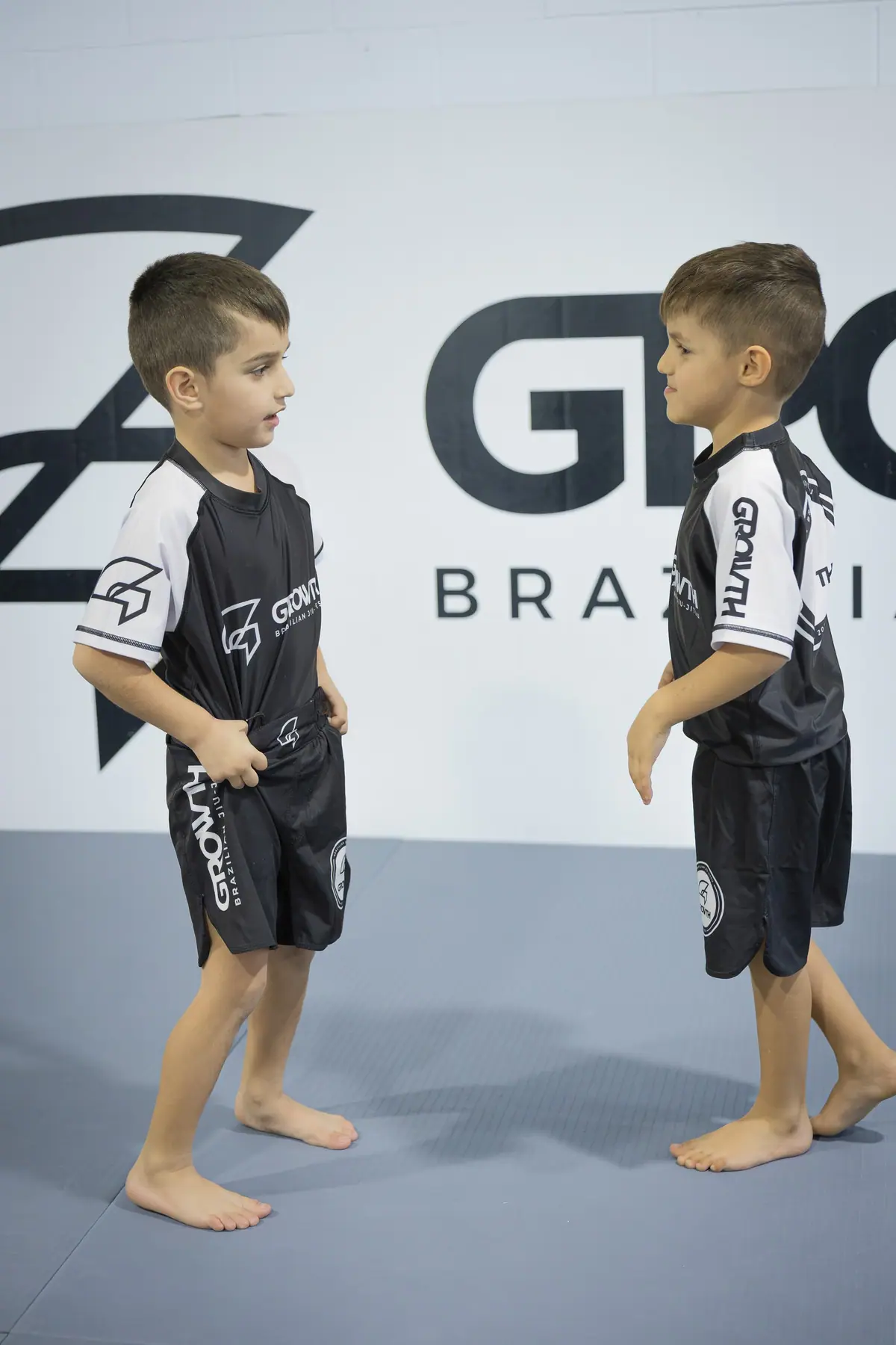 Two boys facing off in front of the Growth wall